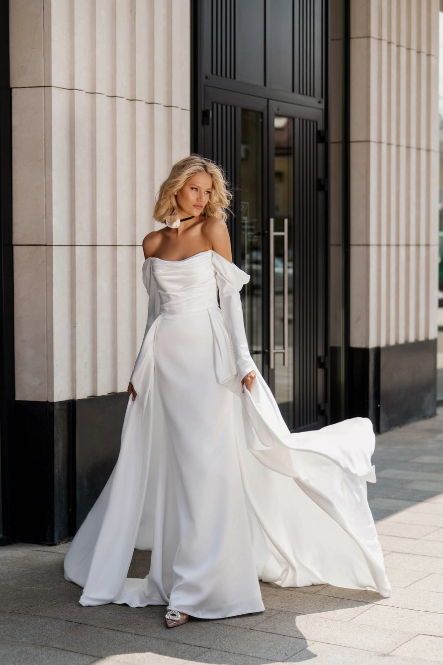 Wedding dress with a fitted silhouette and long sleeves. Complete with a removable skirt.