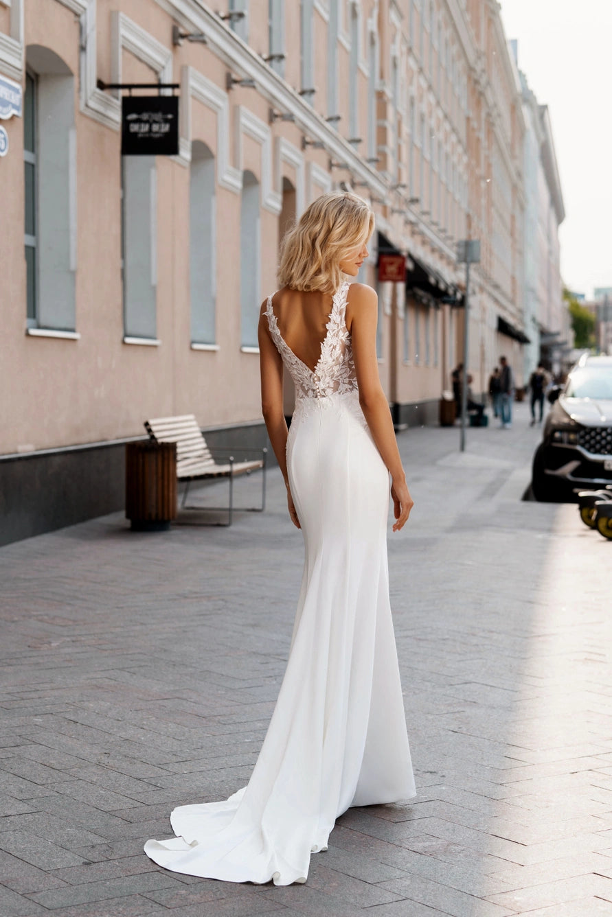 Wedding dress with a fitted silhouette and a small V-neck. The corset is decorated with pearls and beads.