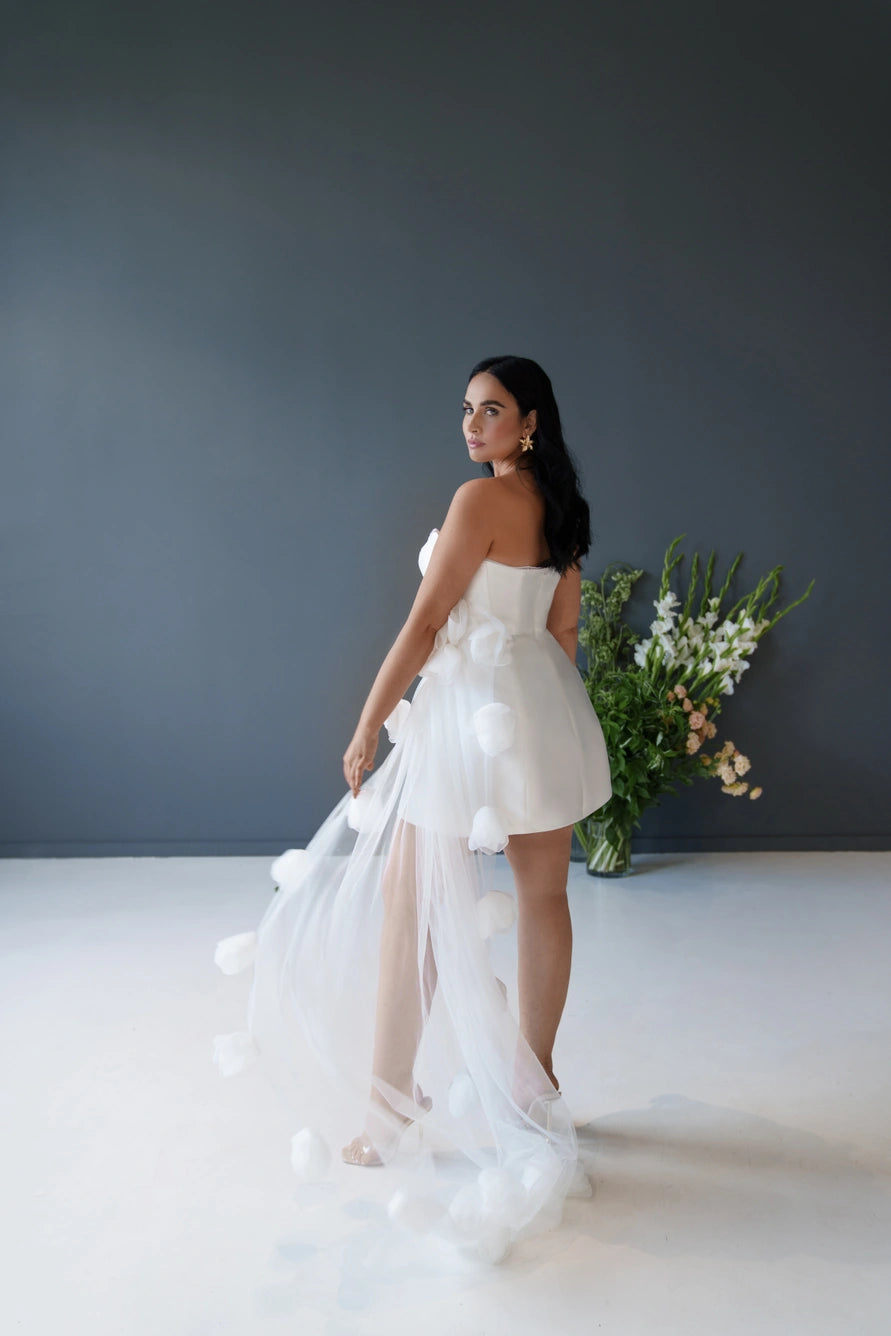 Vestido de novia corto con una falda decorativa con flores 3D.