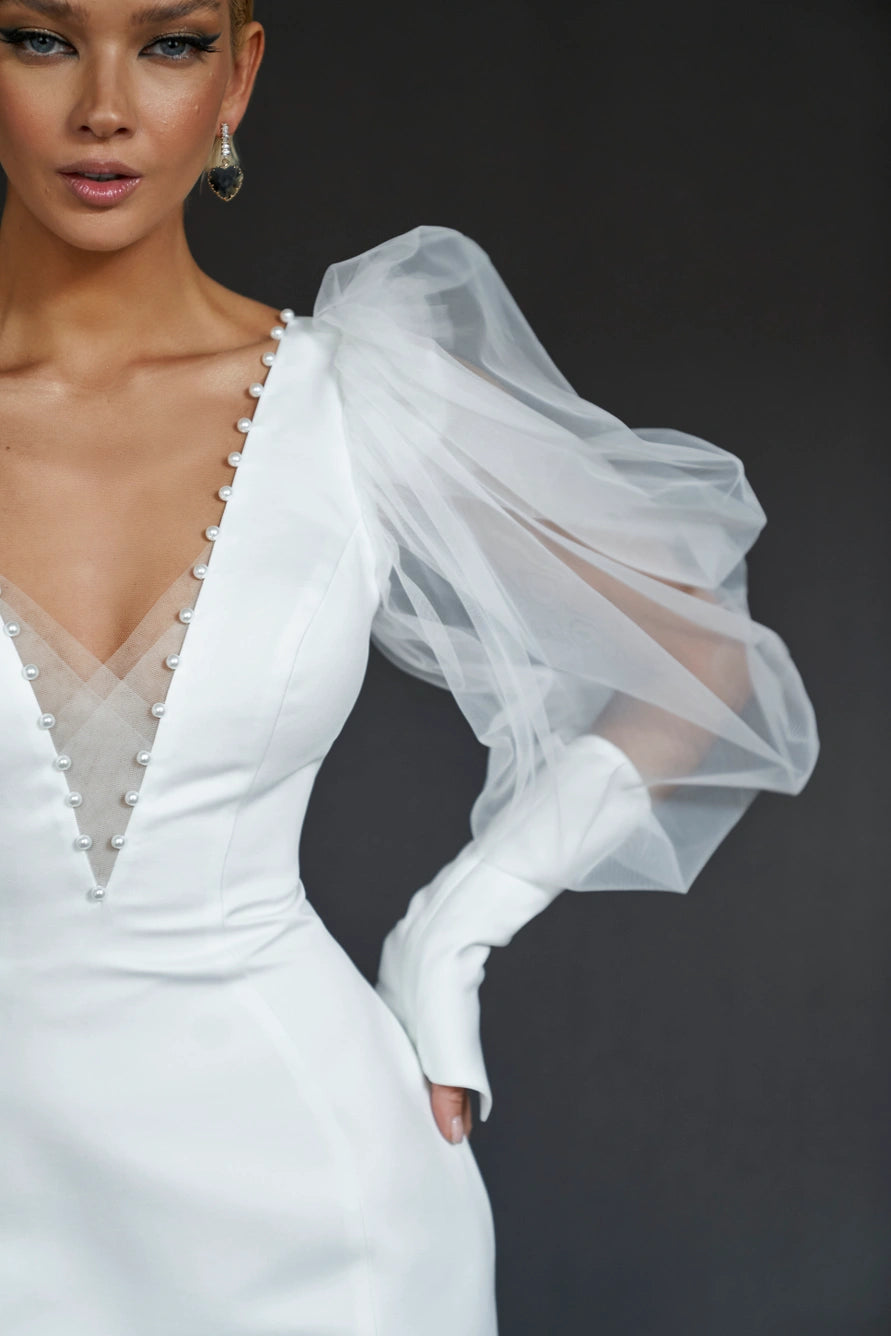 Form fitting midi wedding dress with long puff sleeves and V-shaped neckline. Low back zipper.