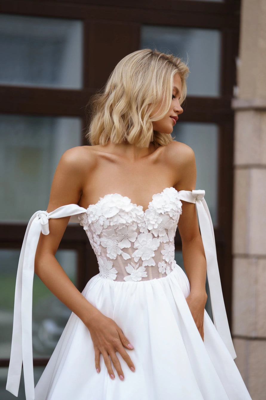 Vestido de novia corto con una falda completa de una línea A y correas caídas.