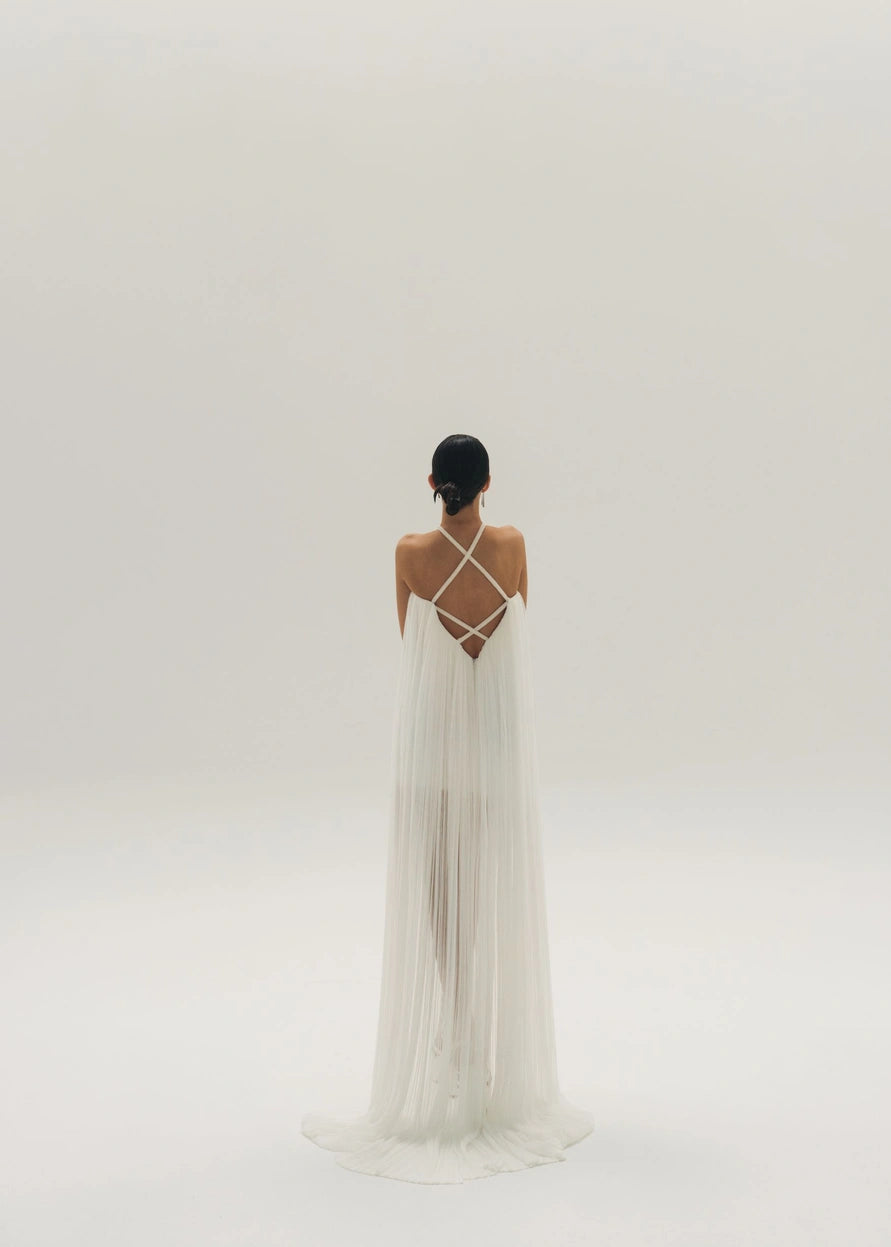 Short wedding dress with a long cape and a back with crossed shoulder straps.