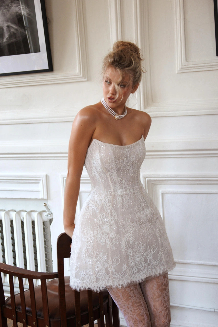 Short wedding dress with long puff sleeves and an open back with a zipper.