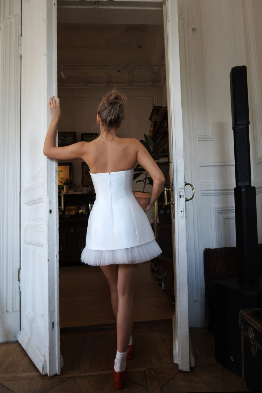 Short wedding dress with long puff sleeves and an open back with a zipper.