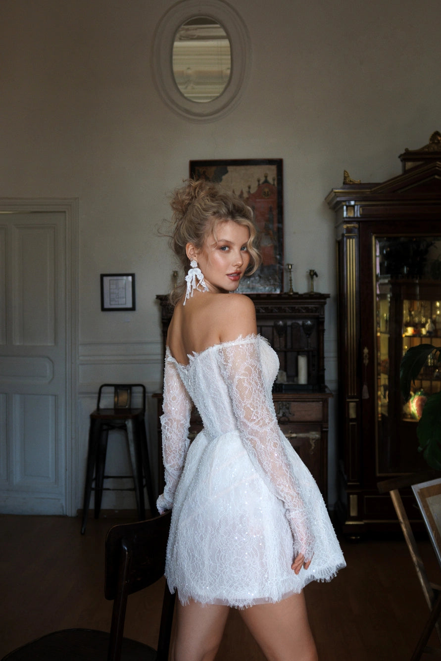 Short wedding dress with long puff sleeves and an open back with a zipper.