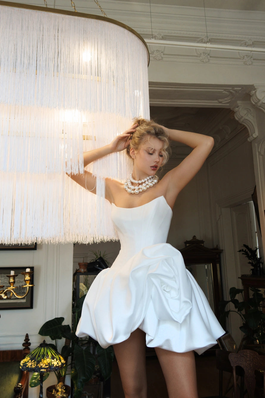 Short wedding dress with long puff sleeves and an open back with a zipper.