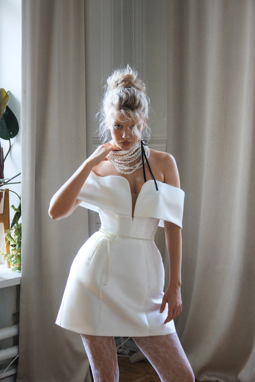 Vestido de novia corto con largas mangas de hojaldre y una espalda abierta con cremallera.