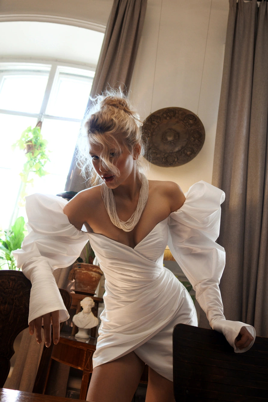 Vestido de novia corto con largas mangas de hojaldre y una espalda abierta con cremallera.