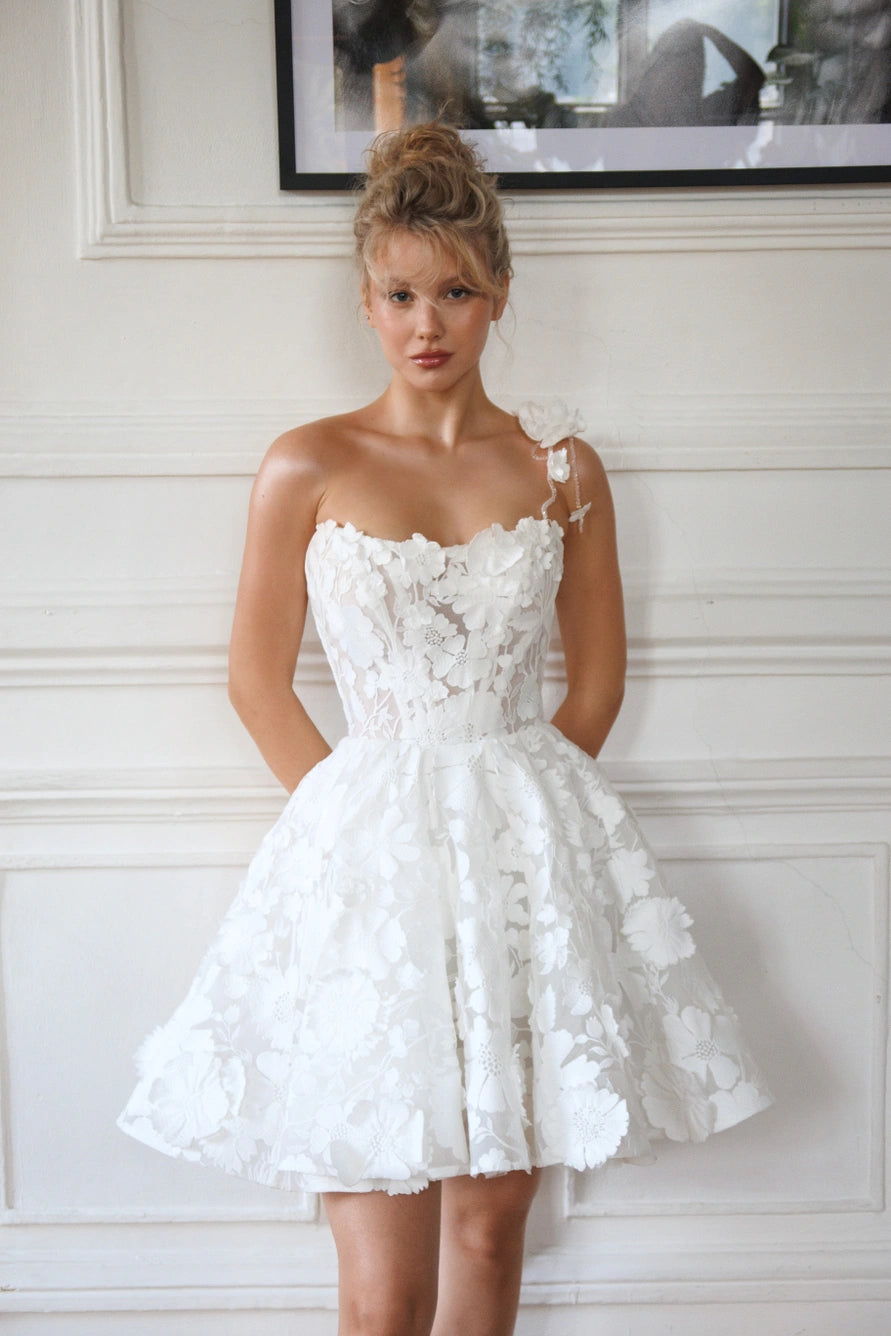 Short wedding dress with long puff sleeves and an open back with a zipper.