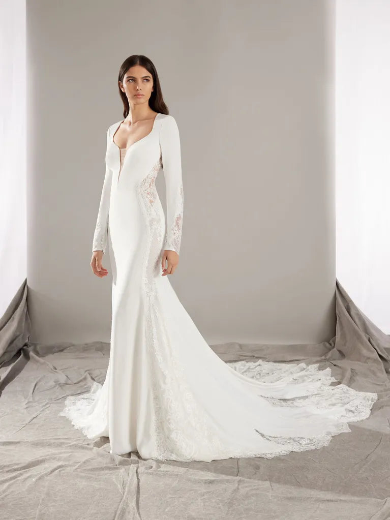 Mermaid wedding dress in crepe with a V-neckline and long sleeves.