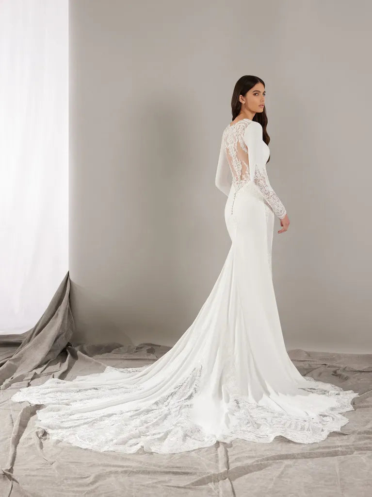 Mermaid wedding dress in crepe with a V-neckline and long sleeves.