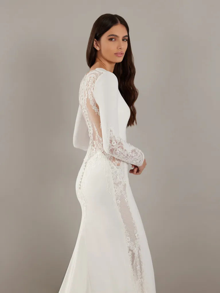 Mermaid wedding dress in crepe with a V-neckline and long sleeves.